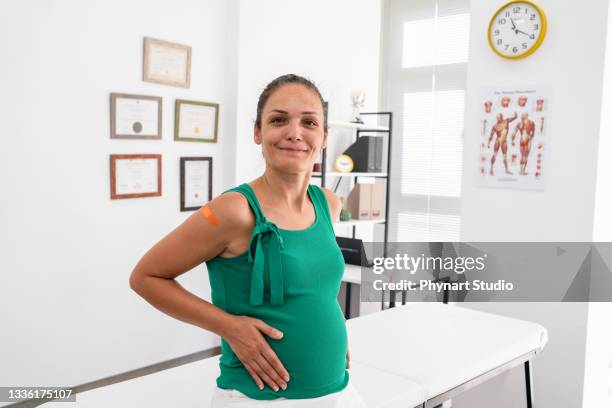schwangere frau nach ihrer covid-19-impfung - portrait woman looking at camera brave stock-fotos und bilder