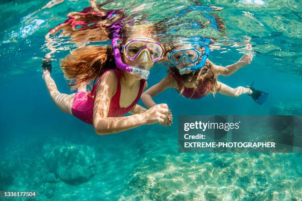 sisters snorkeling and playing underwater - scuba diving girl stock pictures, royalty-free photos & images