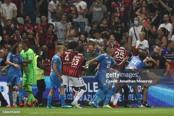 Jean-Clair Todibo of OGC Nice and Boubacar Kamara of Olympique De Marseille pushes a fan back into the stand who appeared to attack Gerson Santos Da...