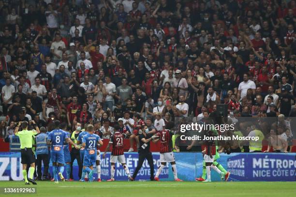 Dante of OGC Nice orders fans back into the stands after the match was suspended following scuffles that broke out on the field of play between OGC...