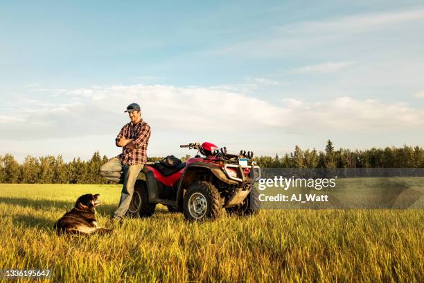 granjero con es quadbike y perro en el campo de la granja - vehículo de todo terreno fotografías e imágenes de stock