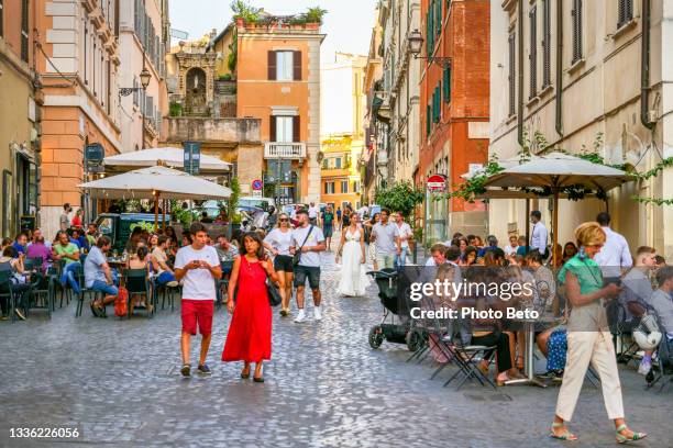 dozens of tourists enjoy life in the sidewalk cafes of piazza della madonna dei monti in the historic heart of rome - old town stock pictures, royalty-free photos & images