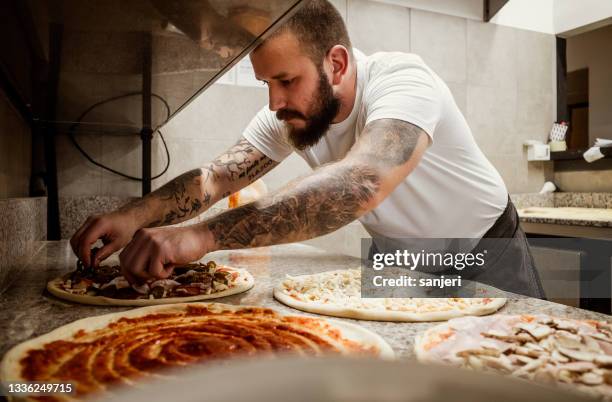 pizza chef working in the kitchen - pizzeria stockfoto's en -beelden