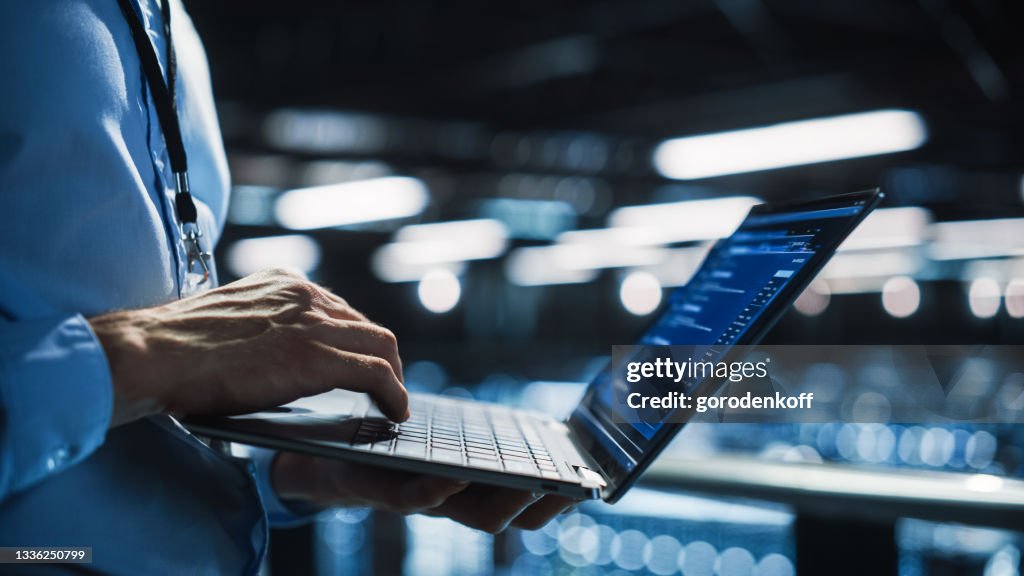 Data Center Programmer Using Digital Laptop Computer, Maintenance IT Specialist. Cloud Computing Server Farm System Administrator Working on Cyber Security for Iaas, saas, paas. Closeup Focus on Hands