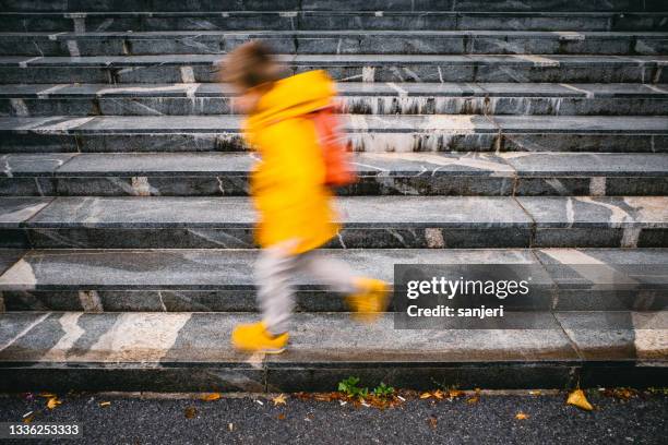 kid walking in the rain, blurred motion - endast en pojke bildbanksfoton och bilder