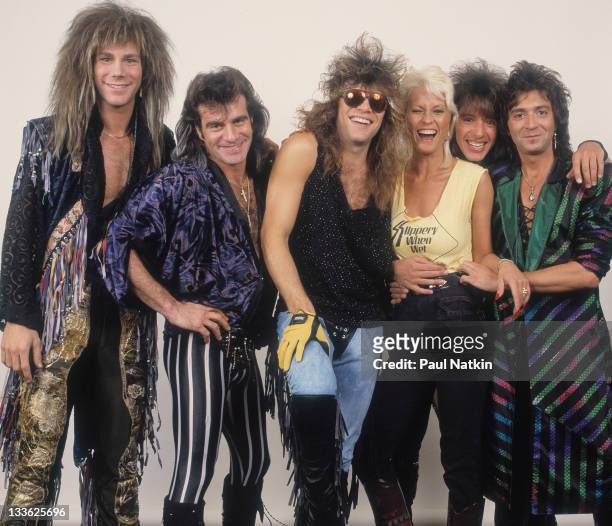 Portrait of American rock band Bon Jovi as they pose with pornographic actress Seka backstage before a performance, Illinois, early March, 1987....