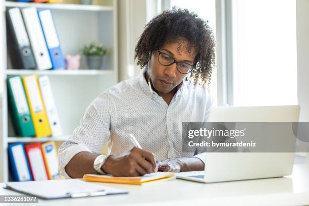 latin-american guy studying at home - listening skills stock pictures, royalty-free photos & images