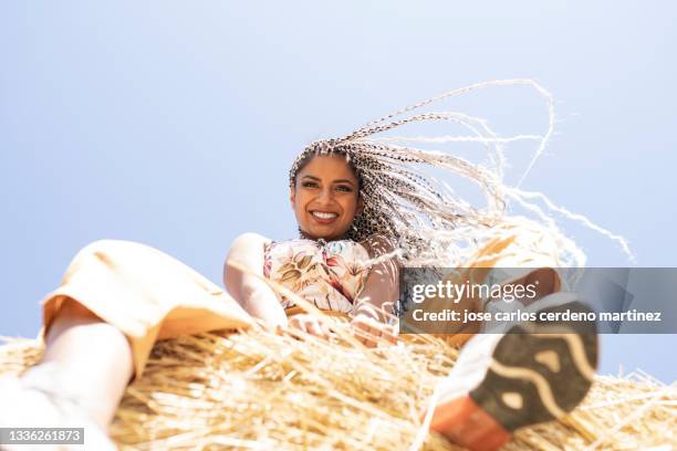 young woman with arms raised standing in the middle of field - woman fingers in ears stock pictures, royalty-free photos & images