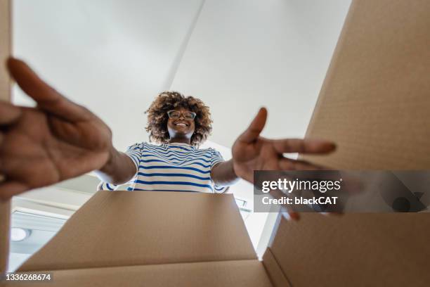 donna sorridente che disimballa le cose fuori dalla scatola - soggettiva foto e immagini stock