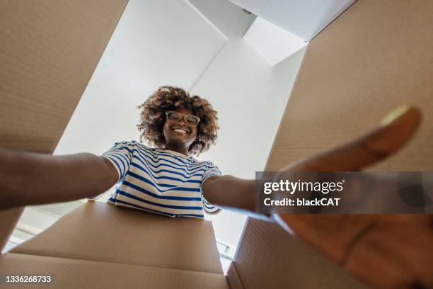 smiling woman unpacking things out of box - new home pov stock pictures, royalty-free photos & images