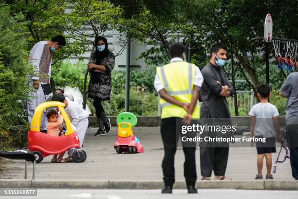 People believed to have recently arrived from Afghanistan stand in the courtyard of a hotel near Manchester Airport on August 25, 2021 in Manchester,...