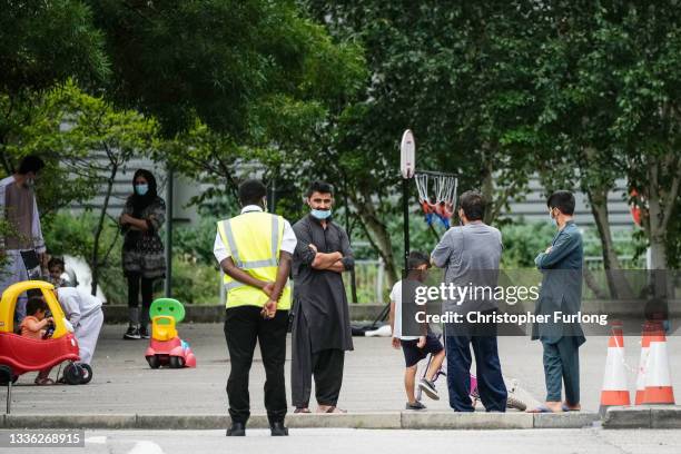 People believed to have recently arrived from Afghanistan stand in the courtyard of a hotel near Manchester Airport on August 25, 2021 in Manchester,...