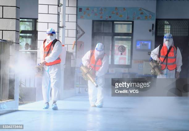Workers disinfect a primary school as new semester approaches on August 25, 2021 in Wuhan, Hubei Province of China.