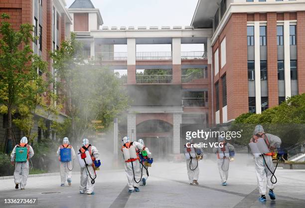 Workers disinfect a primary school as new semester approaches on August 25, 2021 in Wuhan, Hubei Province of China.