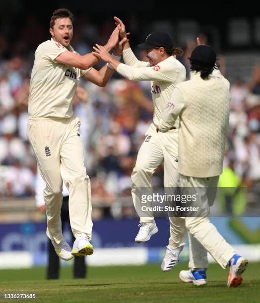 England bowler Ollie Robinson celebrates with team mates after taking the wicket of Rahane during day one of the Third Test Match between England and...