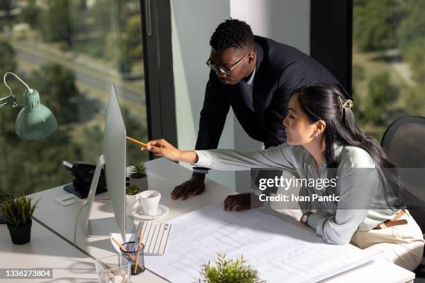 vista ad alto angolo di un piccolo gruppo eterogeneo di giovani architetti colleghi che lavorano insieme nel loro ufficio - efficiency foto e immagini stock