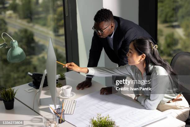 オフィスで一緒に働く若い同僚建築家の小さな多様なグループの高角度の眺め - productivity ストックフォトと画像