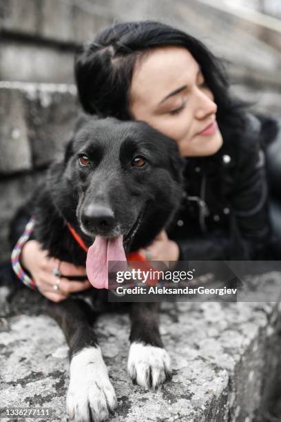 cute female embracing her dog outside on concrete steps - heavy metal texture stock pictures, royalty-free photos & images
