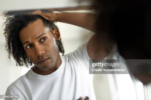 man worried for alopecia checking hair for loss - högt hårfäste bildbanksfoton och bilder