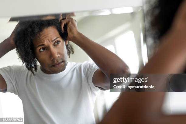 man worried for alopecia checking hair for loss - examining hair stock pictures, royalty-free photos & images