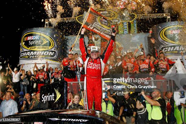 Tony Stewart, driver of the Office Depot/Mobil 1 Chevrolet, celebrates in Victory Lane after winning the NASCAR Sprint Cup Series Ford 400 and the...