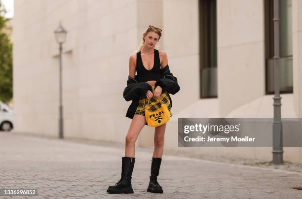 Trixi Giese wearing Prada yellow bag, black vintage bomber jacket, Urban Outfitters black top, Zara yellow skirt and black boots and H&M shades on...