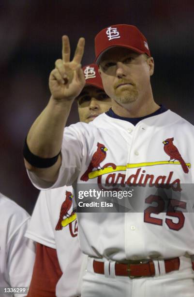 Mark McGwire of the St.Louis Cardinals salutes the crowd during team introductions before Game three of the National League Division Series against...