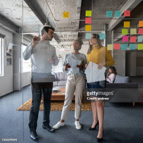 team aziendale che discute una strategia di marketing in una riunione in ufficio - brainstorming foto e immagini stock