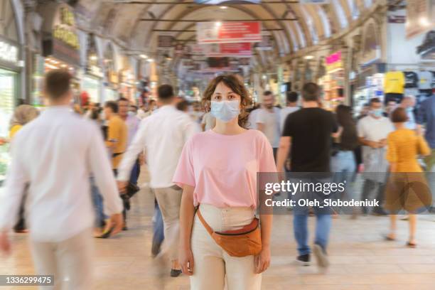 woman in mask standing in the crowd on grand bazaar in istanbul - crowded place stock pictures, royalty-free photos & images