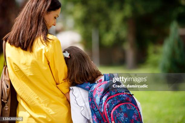 litlle girl with mom on first day of school - leaving school imagens e fotografias de stock