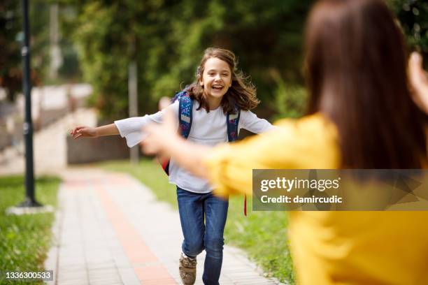happy schoolgirl running to hug mother after school - happy ending stock pictures, royalty-free photos & images