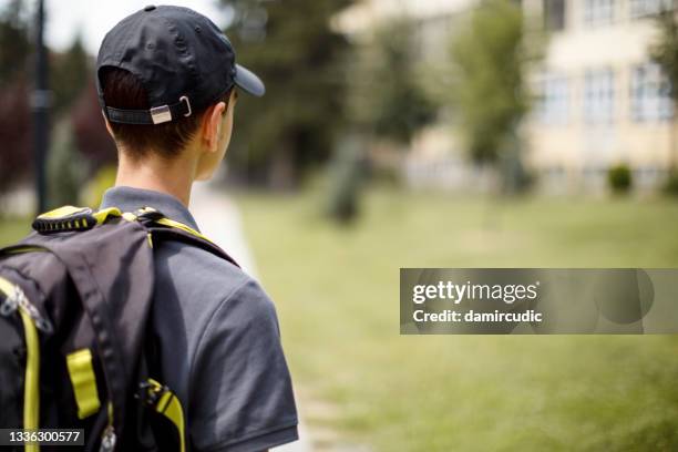rear view of school teenage boy in front of the school - brugklas stockfoto's en -beelden