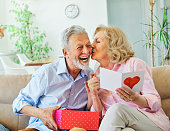 gift woman man couple happy love happiness present kiss romantic smiling together box wife husband elderly old senior mature retired
