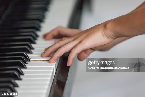 the child's hands on the piano keys. - pianist stock pictures, royalty-free photos & images