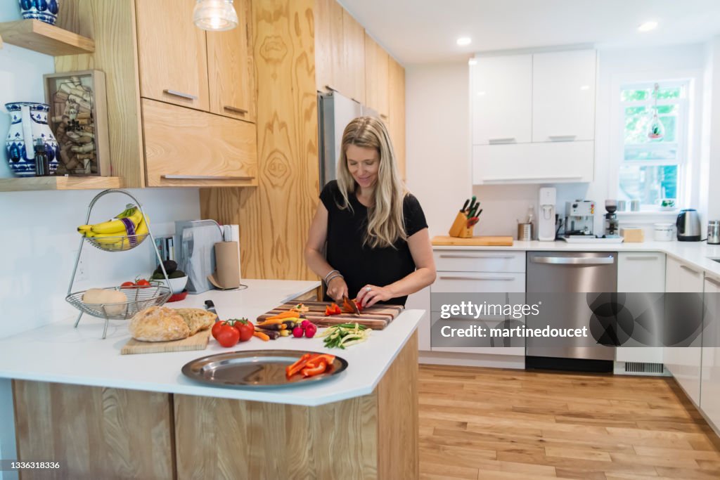 家庭の台所で昼食を準備している女性。
