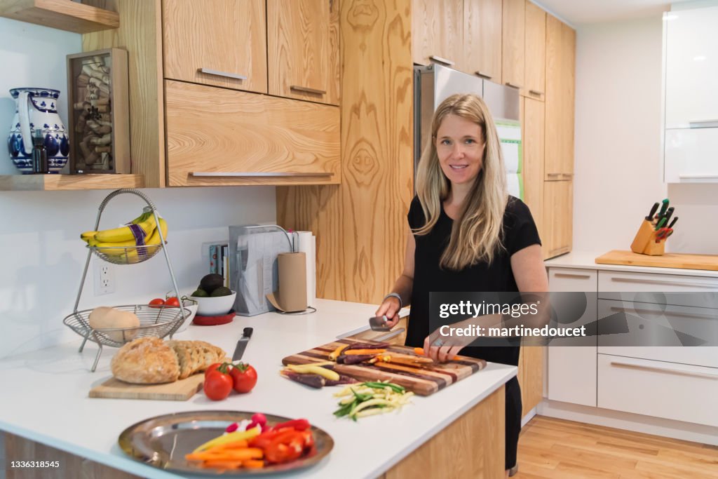 Mulher preparando o almoço na cozinha de casa.