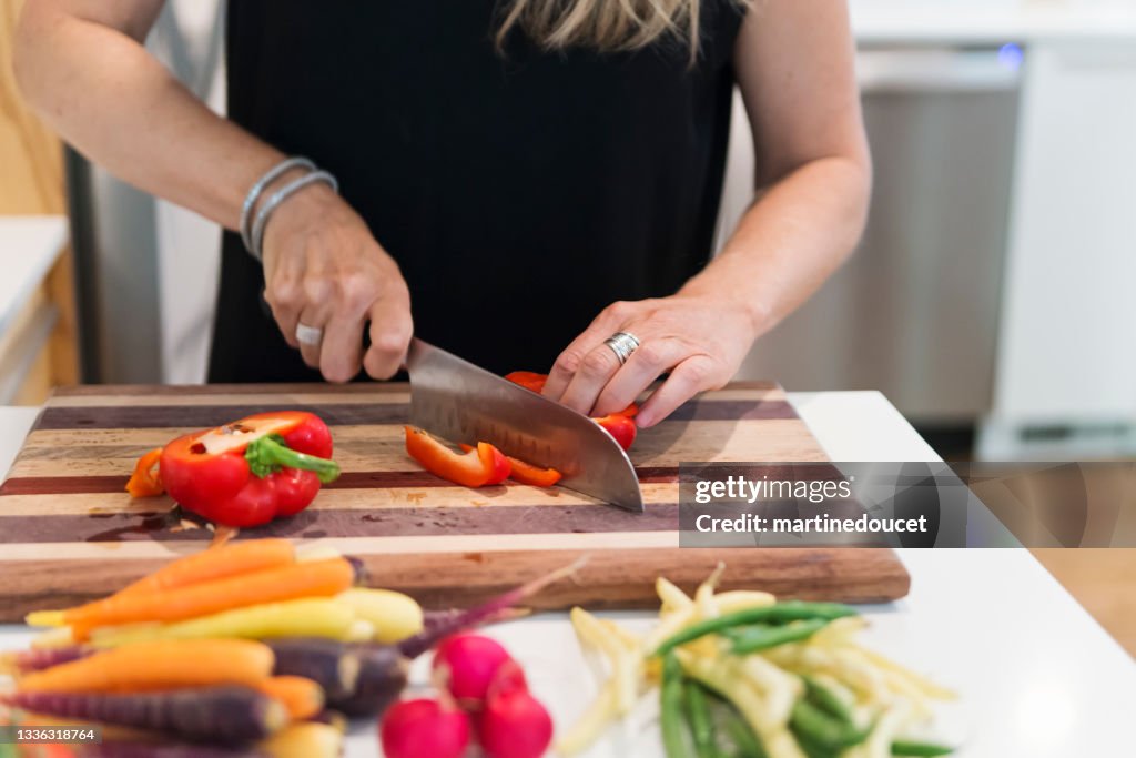 Close-up on woman's hands preparing lunch in home kitchen.
