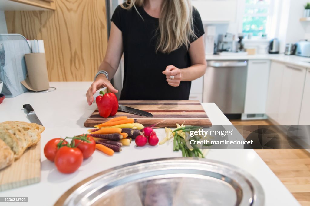 Close-up on woman's hands preparing lunch in home kitchen.