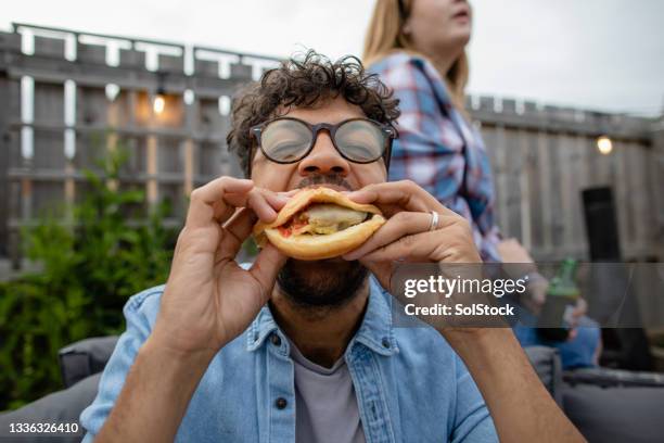 biting into a burger - man holding a burger stock pictures, royalty-free photos & images