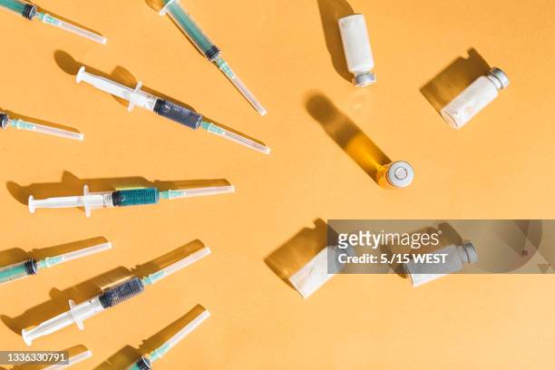 syringes are filled with injection and medical vaccine bottles on a yellow background. flat lay - botoxinjektion bildbanksfoton och bilder