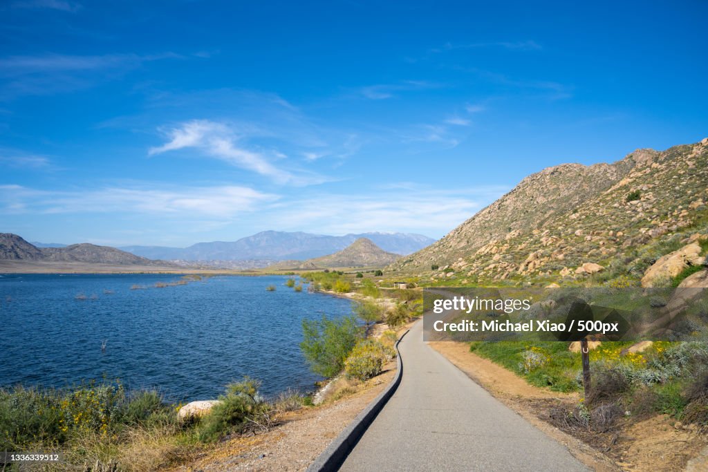 Scenic view of road by mountains against blue sky,Perris Reservoir,California,United States,USA