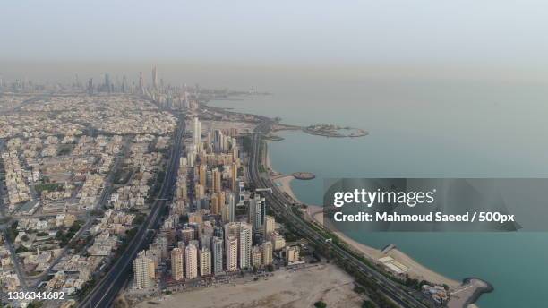 high angle view of buildings by sea against sky,kuwait - kuwait landscape stock pictures, royalty-free photos & images