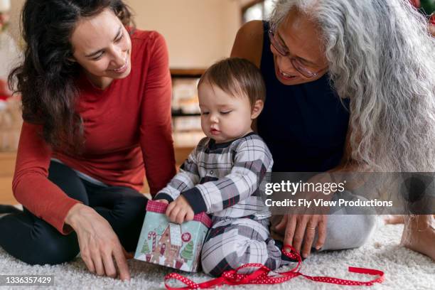 baby opening present - winter baby stock pictures, royalty-free photos & images