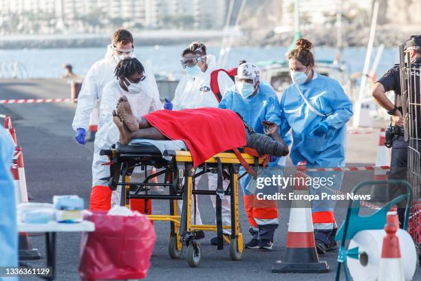 Sanitarians help a migrant man as he disembarks from the guardamar Talia on August 25 in Arguineguin , Canary Islands. Salvamento Maritimo has...