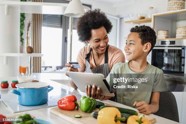 un niño y su madre están ordenando comestibles en línea - adolescentes cocinando fotografías e imágenes de stock