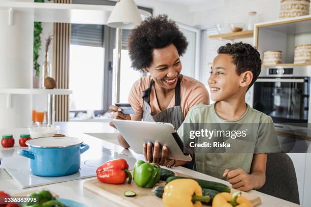 young boy and his mother are ordering groceries online - mother and child cooking stock pictures, royalty-free photos & images