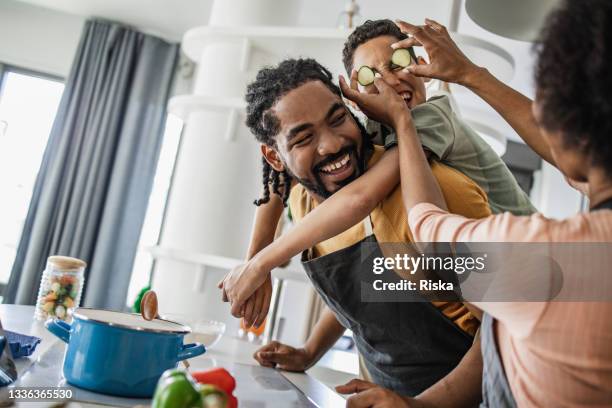 familie mit spaß in der küche - black mother and child cooking stock-fotos und bilder