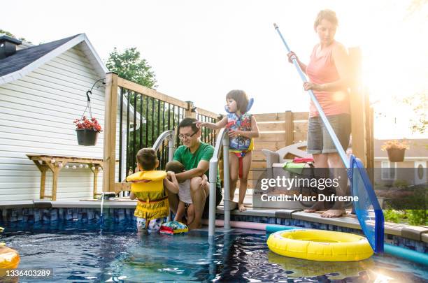 parents and mixed race (chinese and caucasian) children entering in pool - swimming pool cleaning stock pictures, royalty-free photos & images