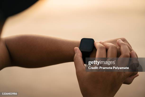 close up hand of a man using the technology of smart watch a heart rate monitor and stress in natural near sunset. smart watch - smart watch stock pictures, royalty-free photos & images