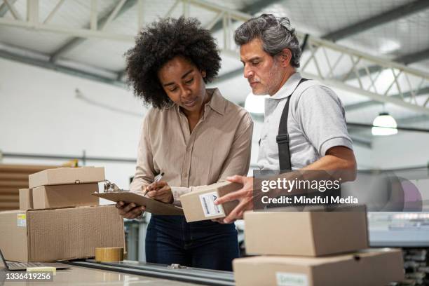 portrait of warehouse colleagues preparing packages for shipping during daytime - post office stock pictures, royalty-free photos & images